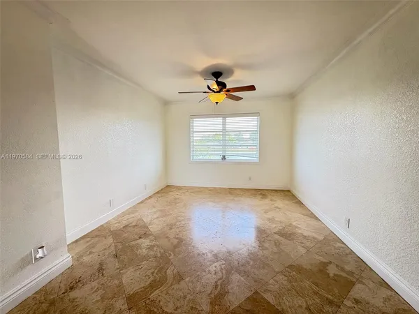 an empty room with a window and a ceiling fan