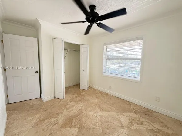 a view of an empty room and a ceiling fan