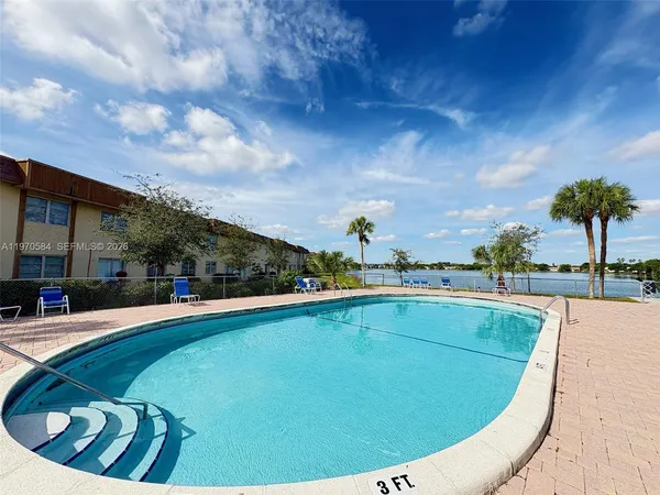 a view of swimming pool with outdoor seating and plants