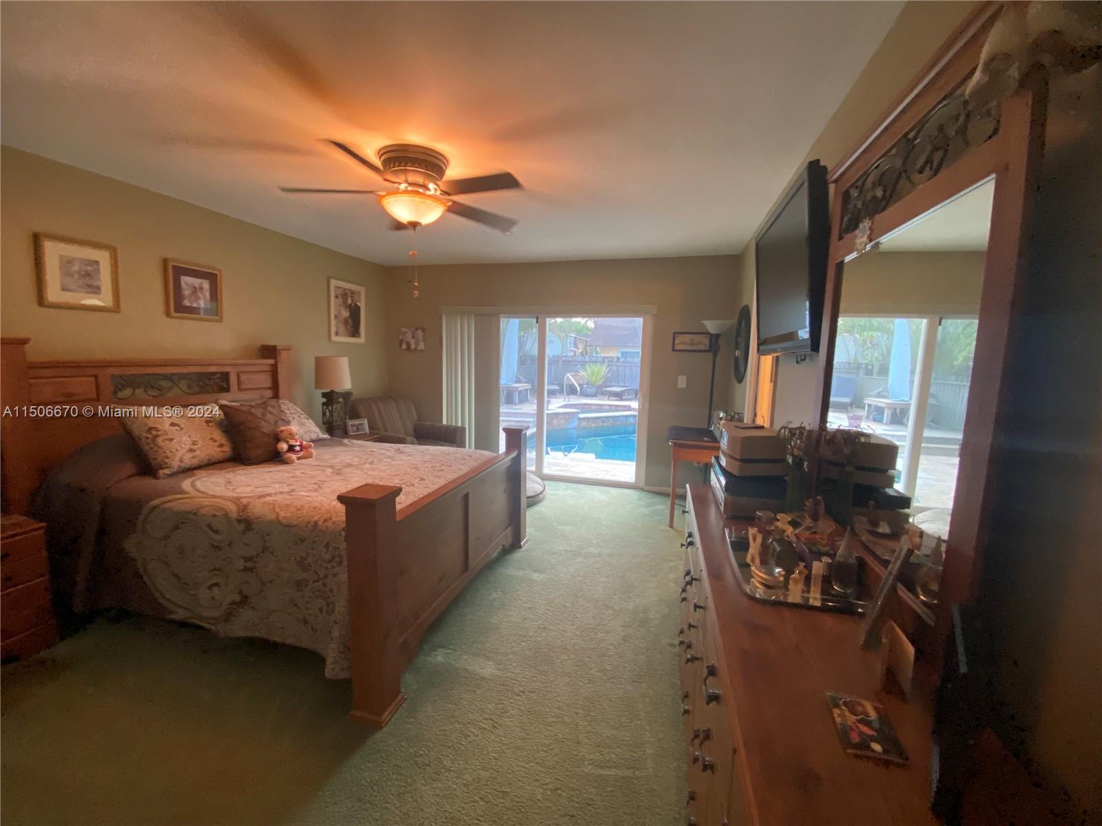 13341 Southwest 101st Street Miami, FL 33186 - Photo 27 of 43 a spacious bedroom with a balcony a bed and a chandelier