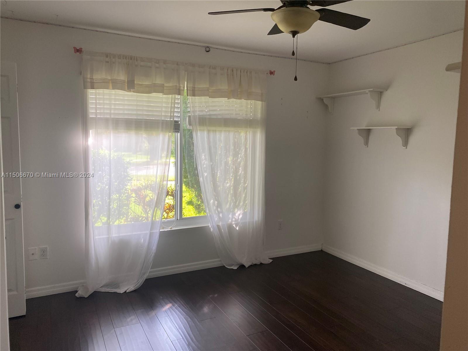 13341 Southwest 101st Street Miami, FL 33186 - Photo 33 of 43 a view of an empty room with wooden floor and a window