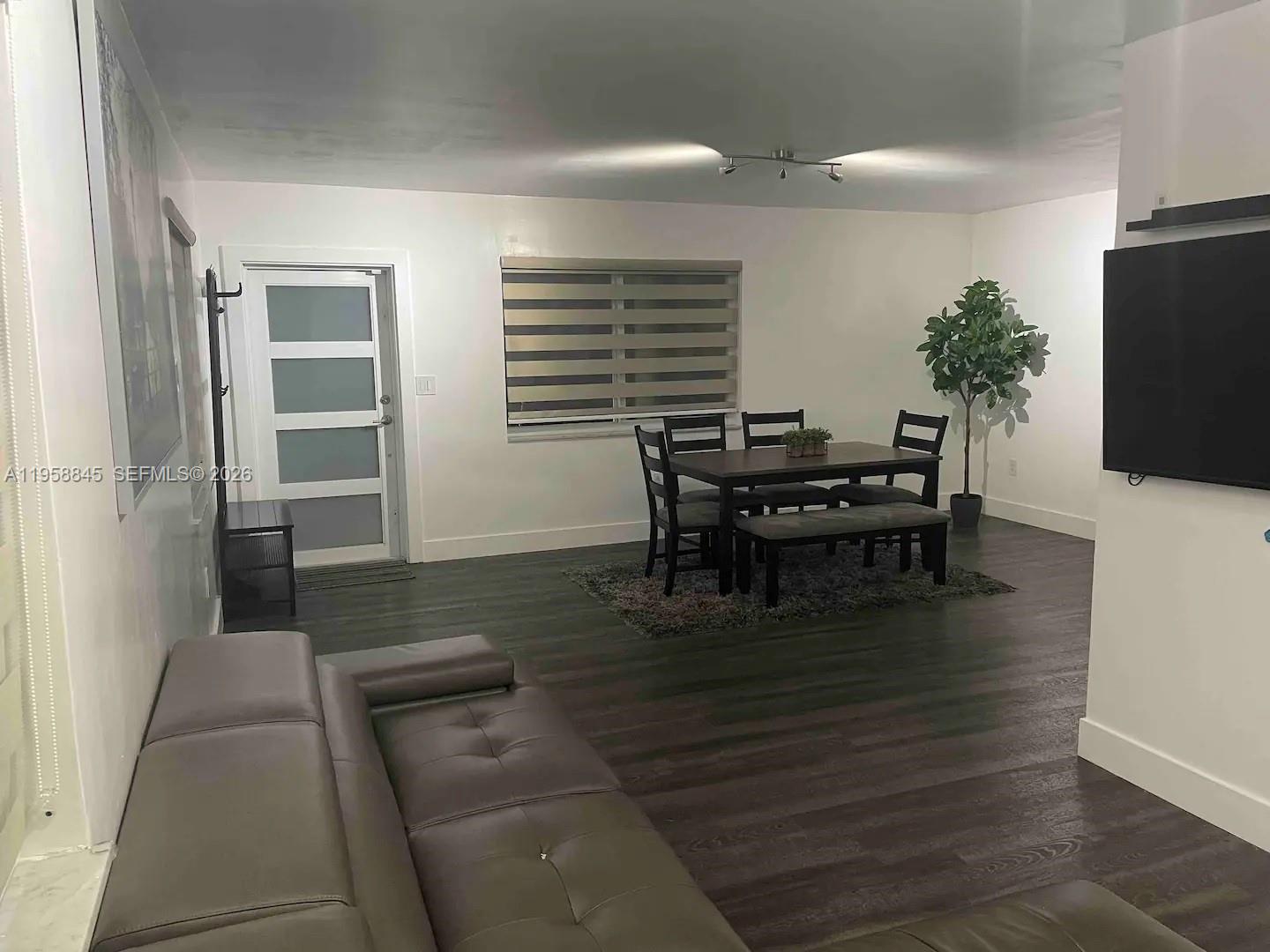 3008 Northwest 13th Street Miami, FL 33125 - Photo 2 of 32 a dining room with furniture and wooden floor
