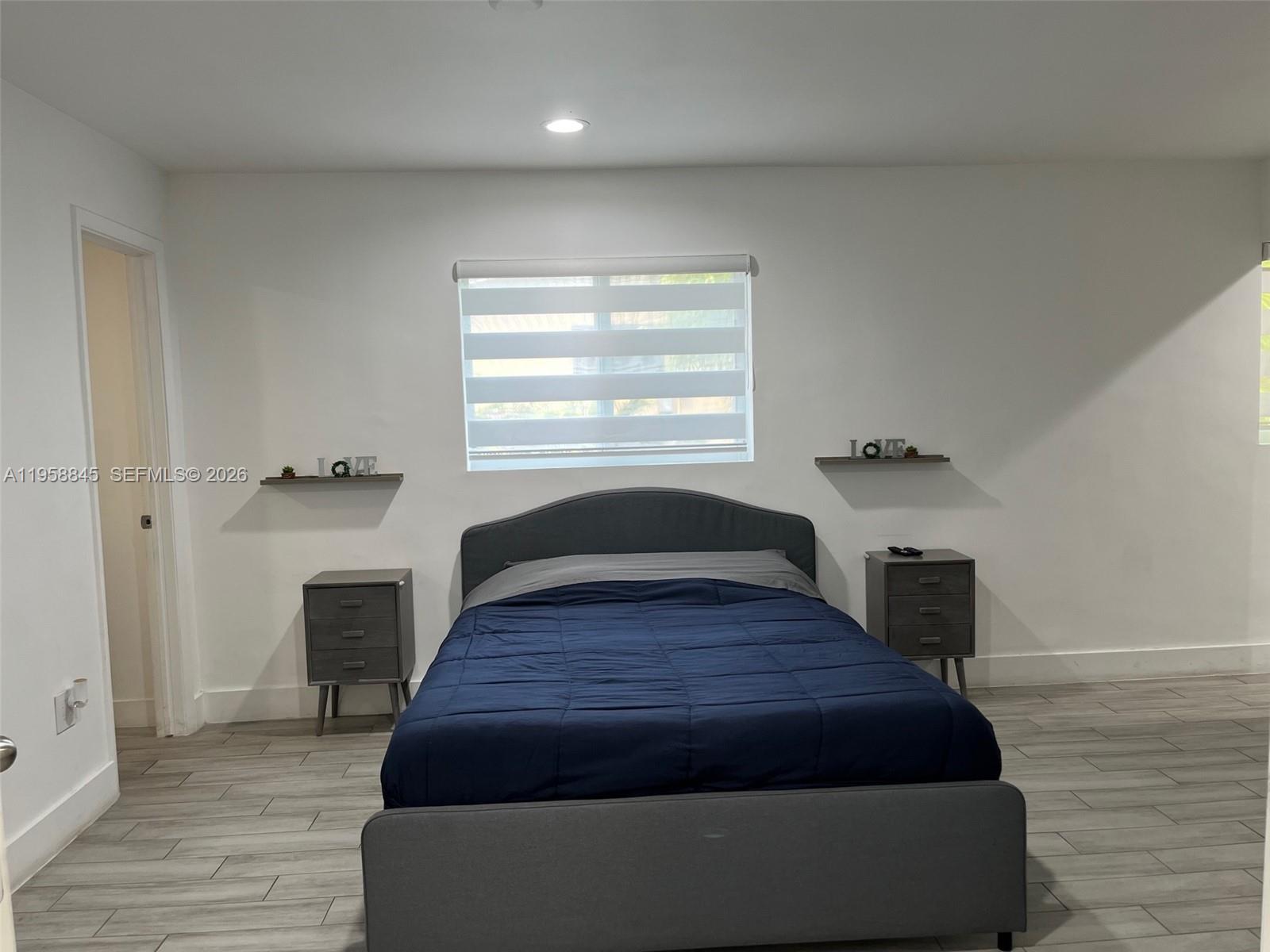 3008 Northwest 13th Street Miami, FL 33125 - Photo 23 of 32 a spacious bedroom with a bed and wooden floor