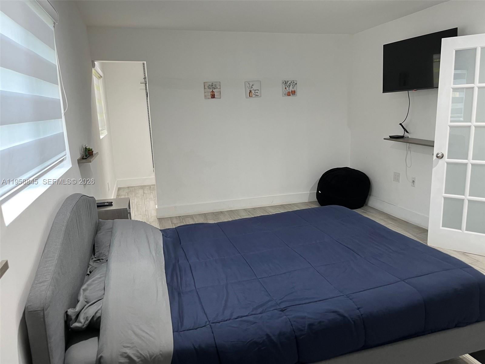 3008 Northwest 13th Street Miami, FL 33125 - Photo 24 of 32 a bedroom with a bed and a flat tv screen