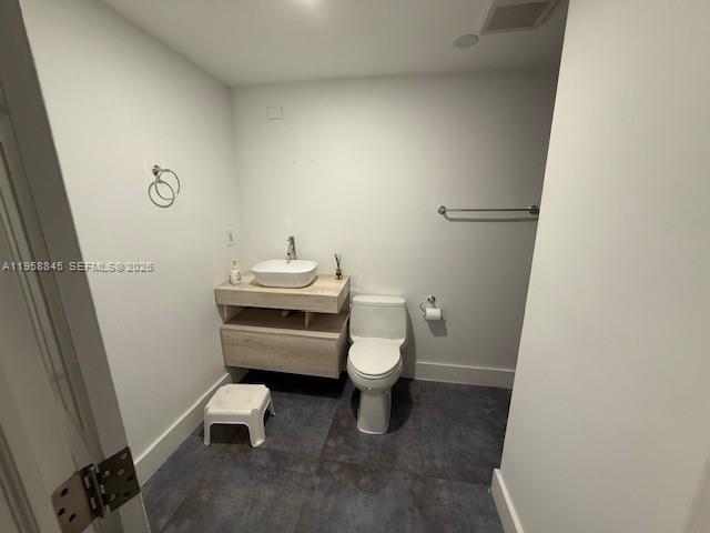 3008 Northwest 13th Street Miami, FL 33125 - Photo 29 of 32 a white toilet sitting next to a white sink and vanity