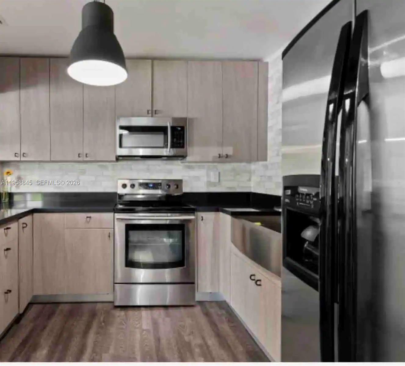 3008 Northwest 13th Street Miami, FL 33125 - Photo 4 of 32 a kitchen with stainless steel appliances a stove a sink and a microwave