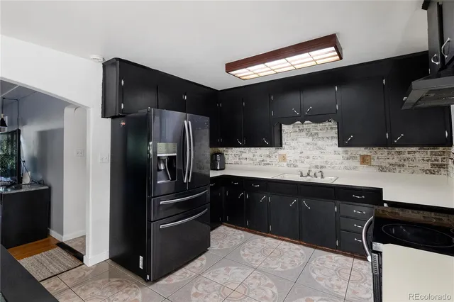 a kitchen with granite countertop a refrigerator and a sink