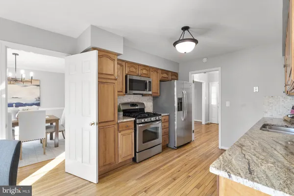 a kitchen with stainless steel appliances granite countertop a refrigerator a stove a sink and a microwave