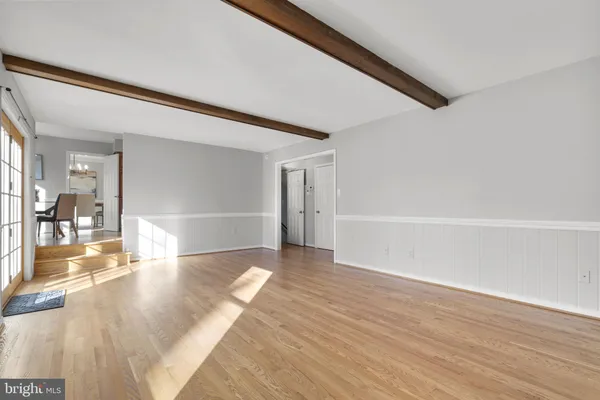 a view of a big room with wooden floor and windows