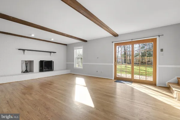 a view of a big room with wooden floor and windows