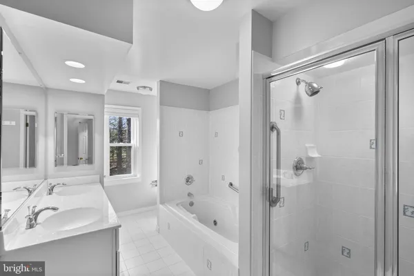 a bathroom with a bath tub sink mirror and shower