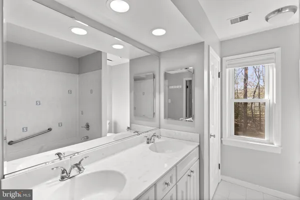 a bathroom with double vanity sinks and a mirror