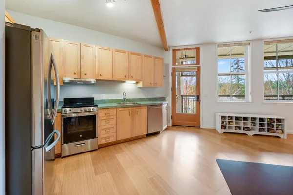 a kitchen with stainless steel appliances granite countertop a stove a sink and a refrigerator