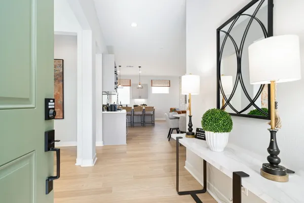 a living room with furniture a mirror and white walls
