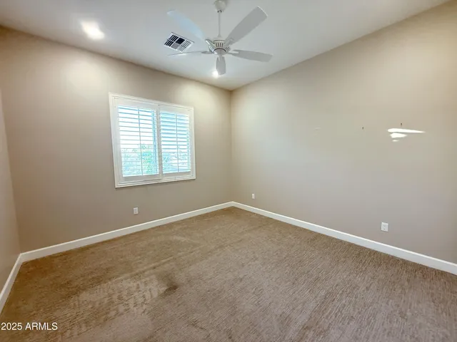 an empty room with fan and entryway