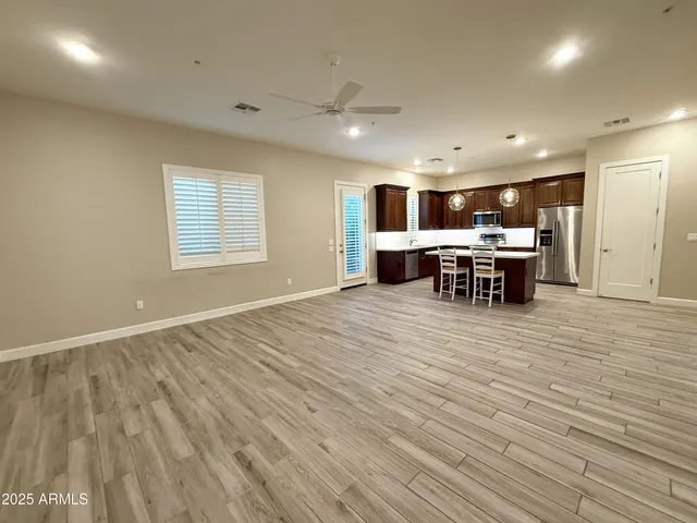 an open kitchen with kitchen island a sink dishwasher a dining table and chairs with wooden floor