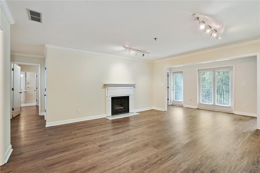 3203 Lenox Road Northeast, Unit 6 Atlanta, GA 30324 - Photo 4 of 27 a view of an empty room with wooden floor and a window