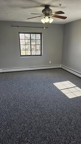en empty room with windows and ceiling fan