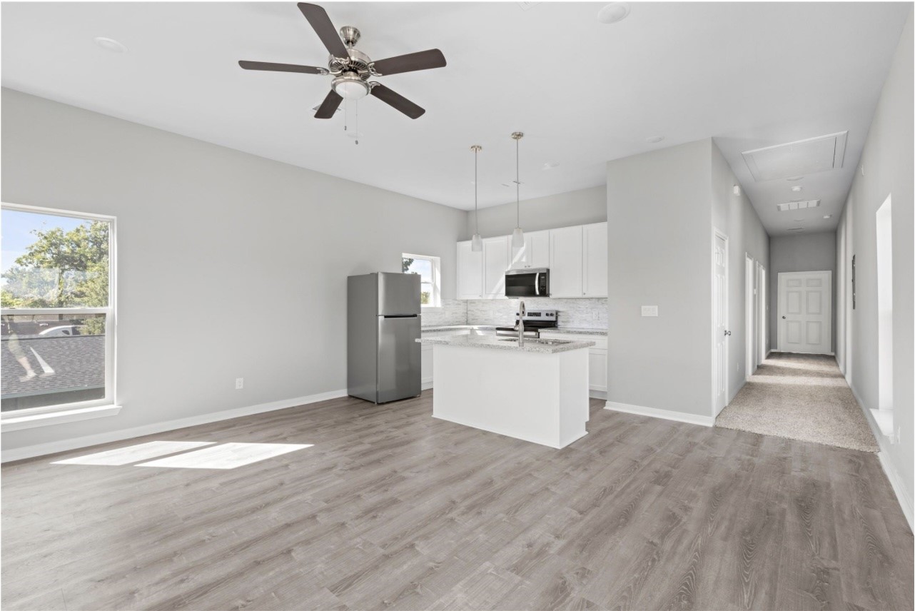 a view of kitchen with stainless steel appliances kitchen island hardwood floor and window
