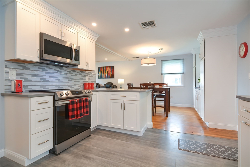 123 Capper Drive Canton, MA 02021 - Photo 4 of 32 a kitchen with granite countertop a stove top oven and cabinets