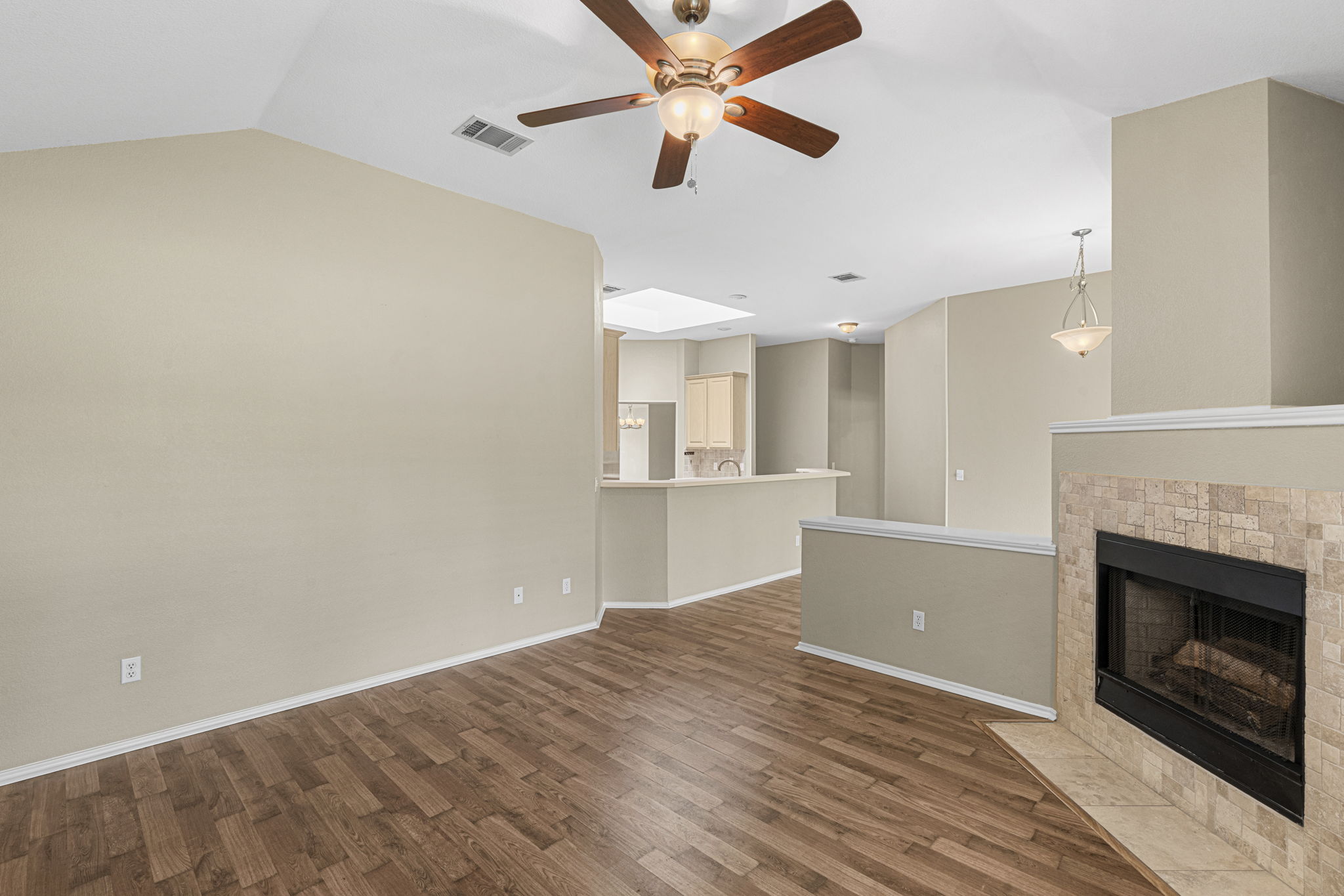 7172 Ridge Oak Road Austin, TX 78749 - Photo 28 of 40 A well-lit living area features an elegant fireplace with stone surround, complemented by rich hardwood flooring.