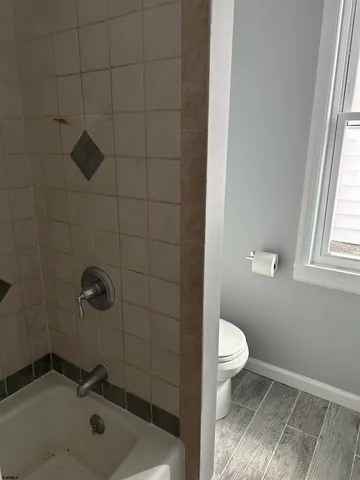 a bathroom with a sink toilet and window