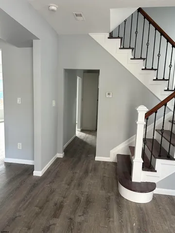 a view of entryway and hall with wooden floor