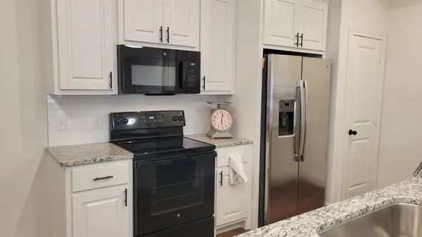 a kitchen with a refrigerator stove and microwave