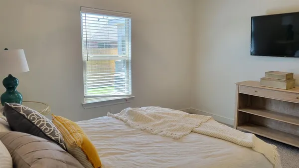 a bedroom with a bed and a flat screen tv