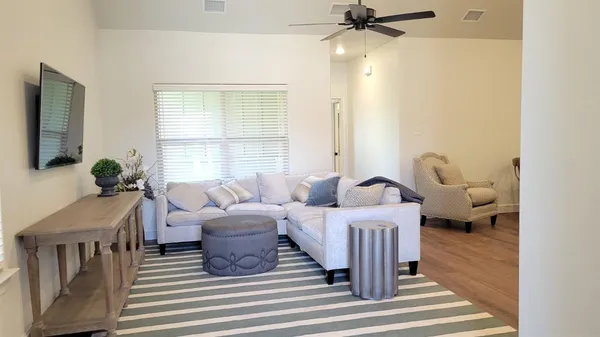 a living room with furniture a chandelier and a window