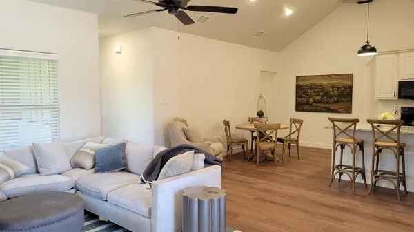 a living room with furniture and a wooden floor
