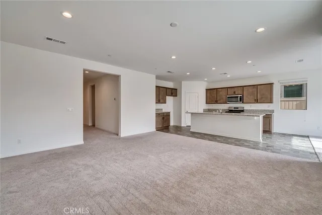 a view of a kitchen with a sink wooden cabinets and a window