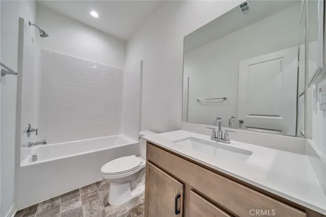 a bathroom with a sink a toilet and a large mirror