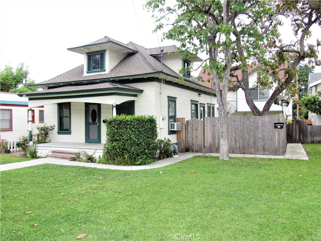 a front view of a house with a yard and trees