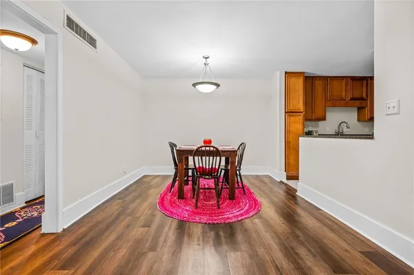 a view of a room with wooden floor table and chairs