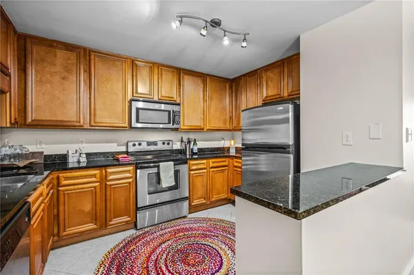 a kitchen with stainless steel appliances granite countertop a refrigerator a stove top oven a sink and dishwasher
