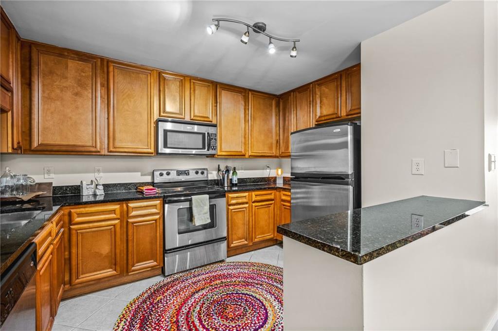1468 Briarwood Road Northeast, Unit 401 Brookhaven, GA 30319 - Photo 12 of 26 a kitchen with stainless steel appliances granite countertop a refrigerator a stove top oven a sink and dishwasher