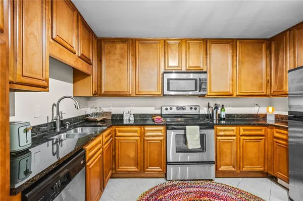 a kitchen with stainless steel appliances granite countertop a stove a sink and a microwave
