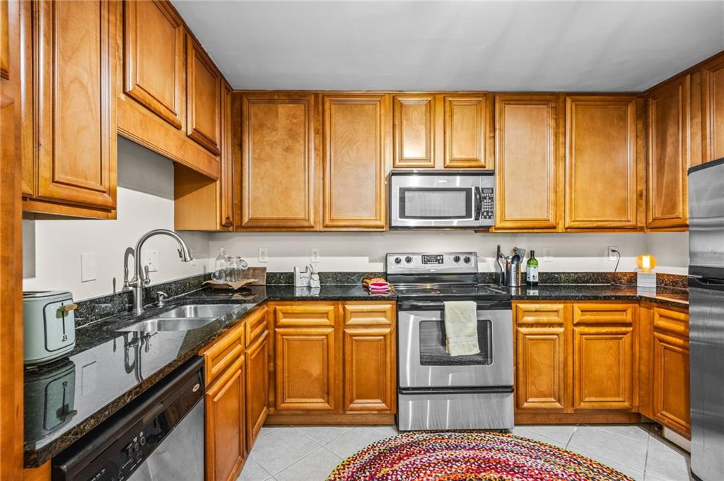 1468 Briarwood Road Northeast, Unit 401 Brookhaven, GA 30319 - Photo 13 of 26 a kitchen with stainless steel appliances granite countertop a stove a sink and a microwave
