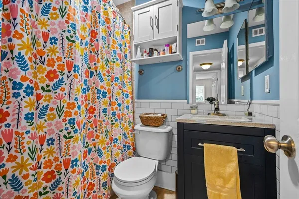 a bathroom with a granite countertop sink and a toilet