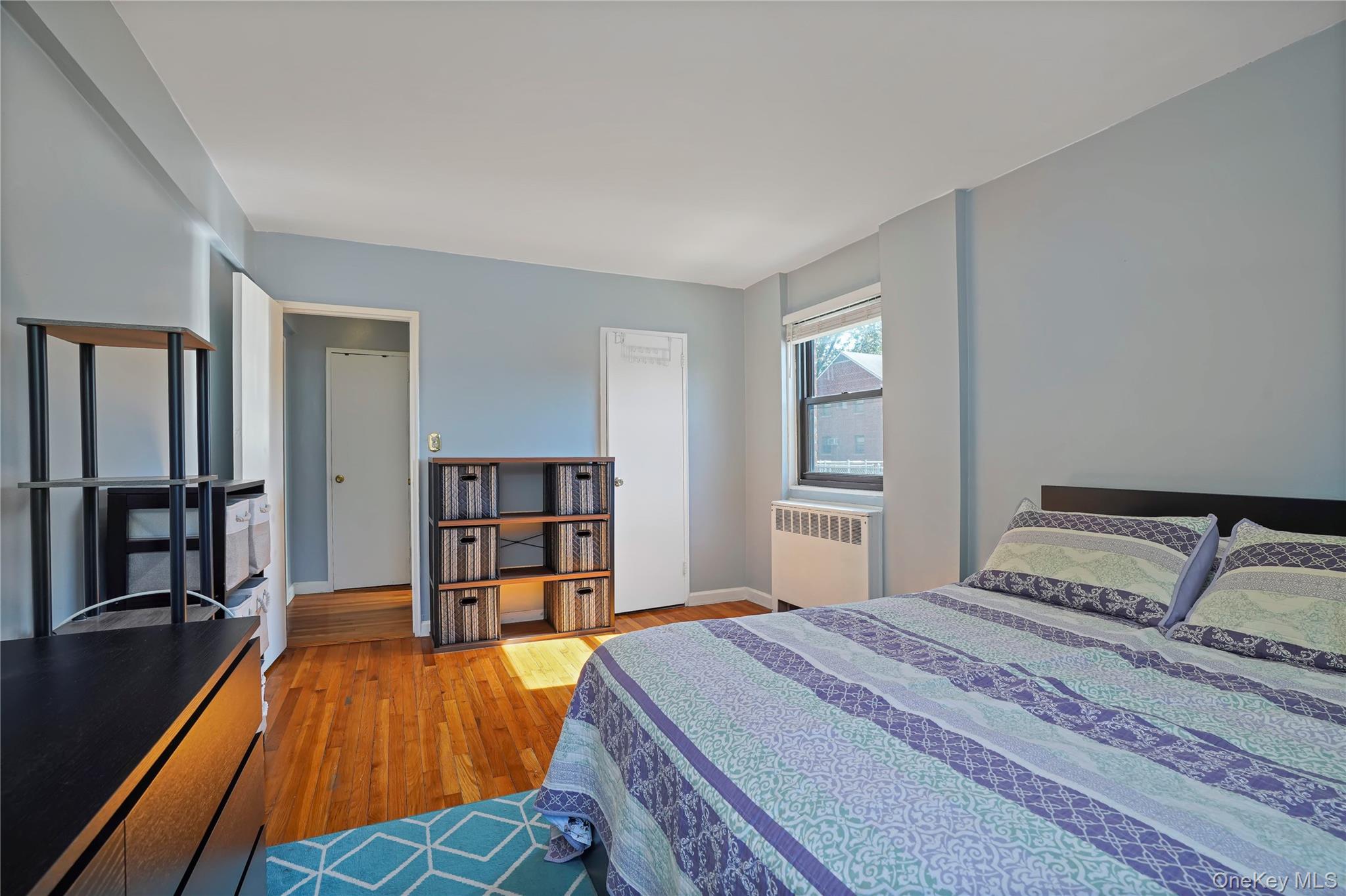 84-18 155th Avenue, Unit 1R Queens, NY 11414 - Photo 18 of 26 a bedroom with a bed and a wooden floor