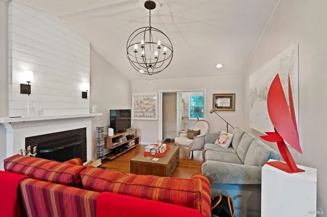 a living room with furniture a fireplace and a chandelier