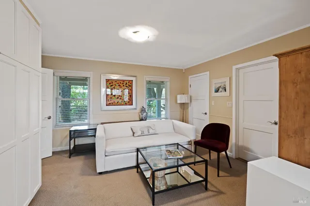a living room with furniture a large window and a table