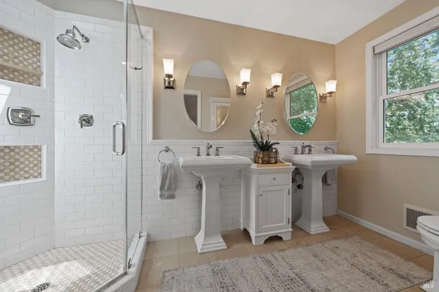 a bathroom with a double vanity sink mirror and shower