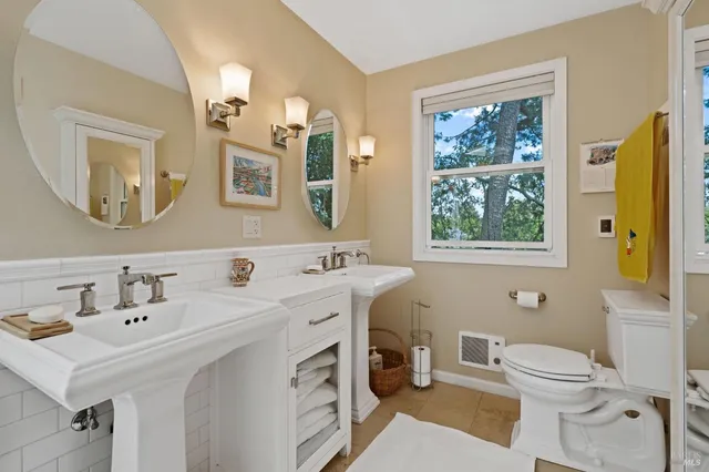 a bathroom with a sink mirror and toilet