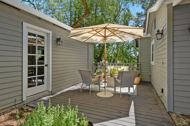 a view of a patio with table and chairs with wooden floor and plants