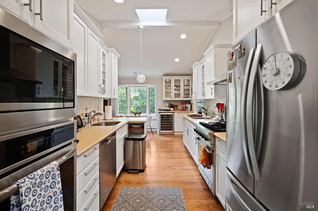 a kitchen with stainless steel appliances granite countertop a refrigerator a stove a sink and a stove