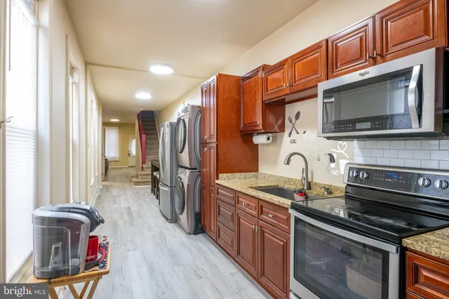 a kitchen with stainless steel appliances granite countertop a sink stove and cabinets