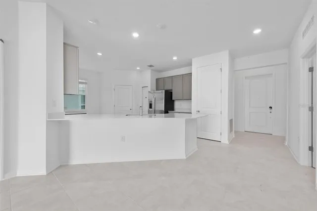 a kitchen with stainless steel appliances granite countertop a refrigerator a stove and a sink