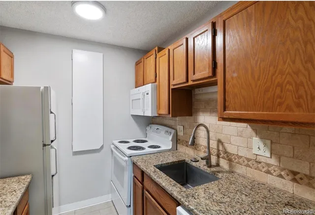 a kitchen with stainless steel appliances granite countertop a refrigerator and a stove